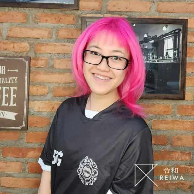 Cliente com coloração rosa vibrante e franja, publicada pelo Studio Reiwa Vila Romana